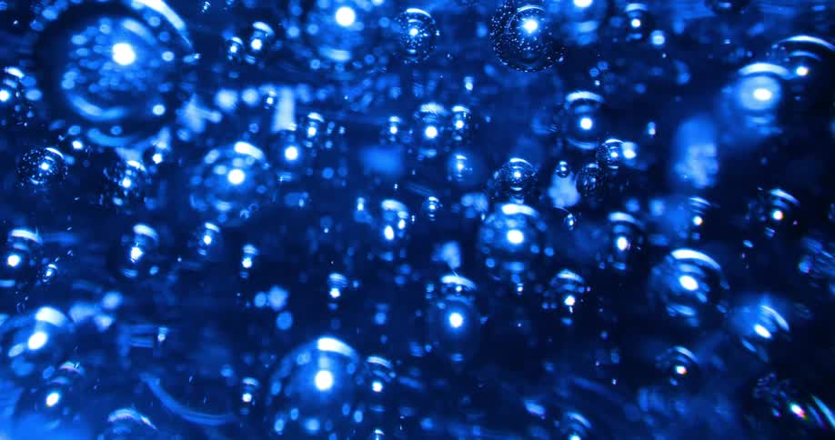 Numerous bubbles are embedded within an blue glass sphere that is rotating