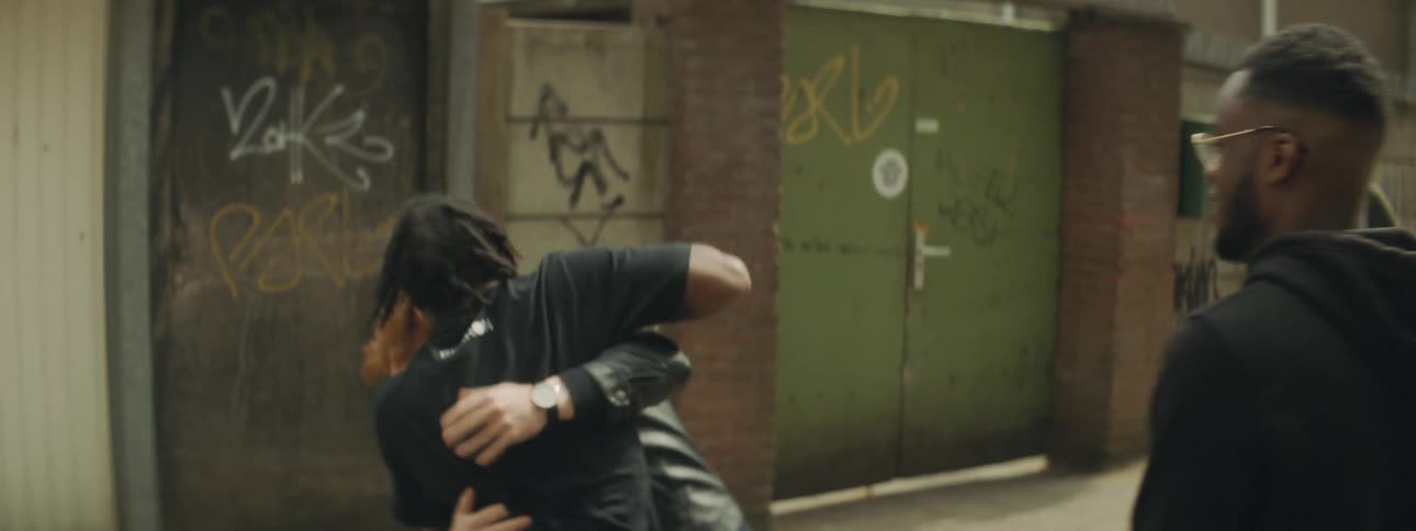 Man tries to hold another back as third man taunts him