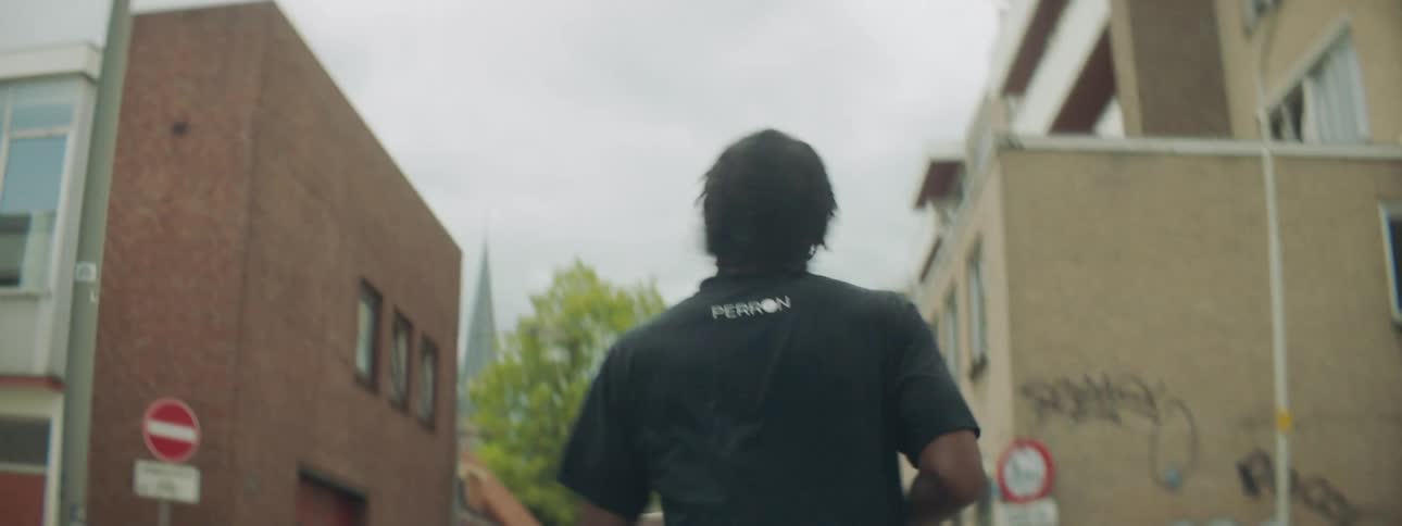 A man is jogging down the street