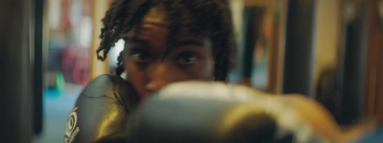 Male boxer with boxing gloves throws punches in the gym