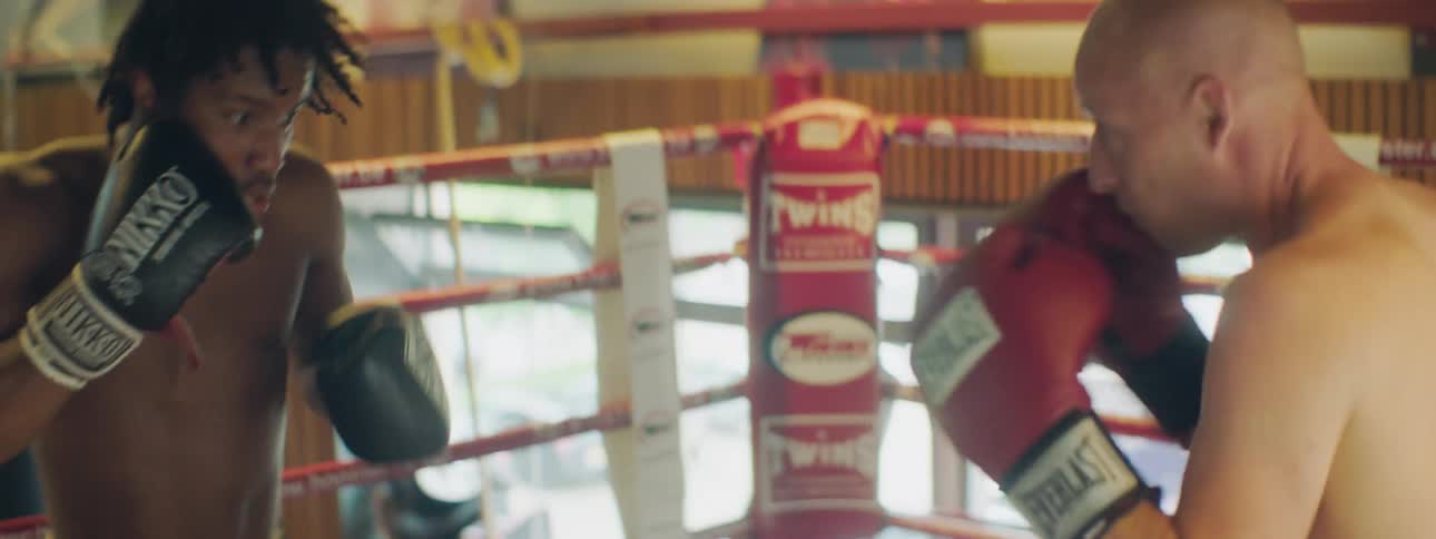 Two men box each other in a boxing ring