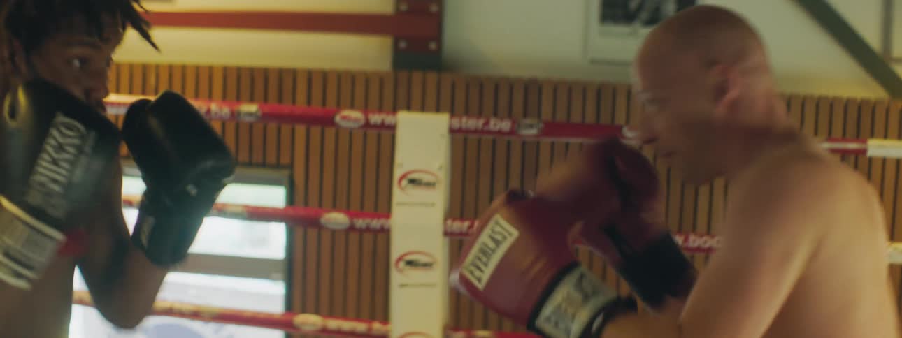 Two men box each other in a boxing ring