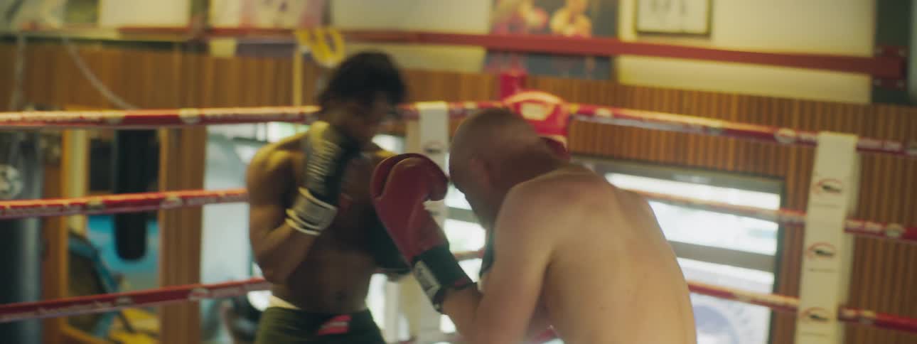 Two men throwing punches at one another in a boxing ring