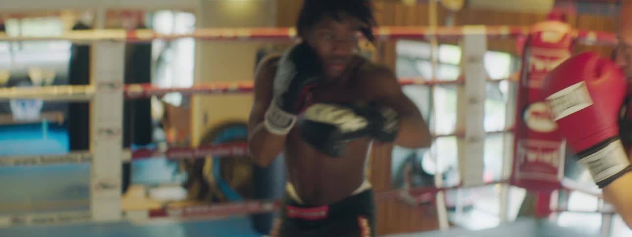 Two men box each other in a boxing ring