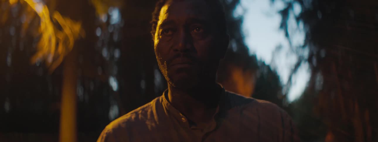 A man is standing outdoors at night
