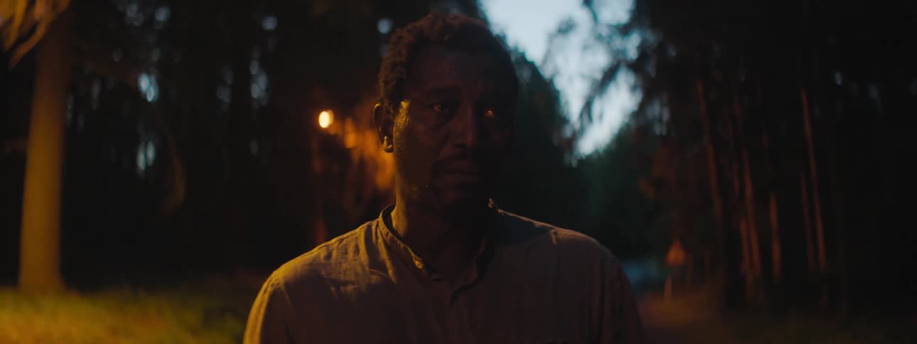 A man is standing outdoors at night