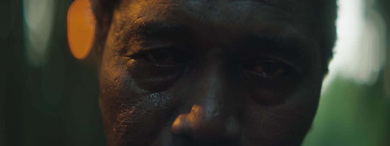 A sad older man blinking and crying outside