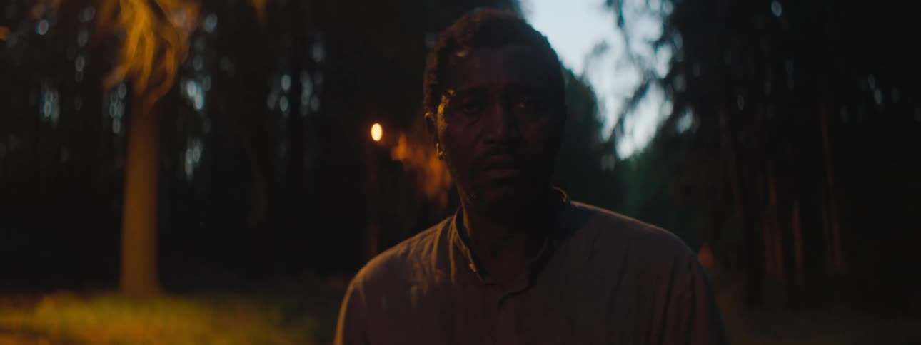 A man is walking outdoors at night