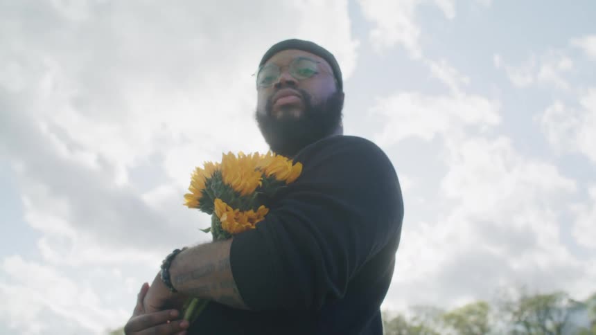A man is holding a bunch of sunflowers