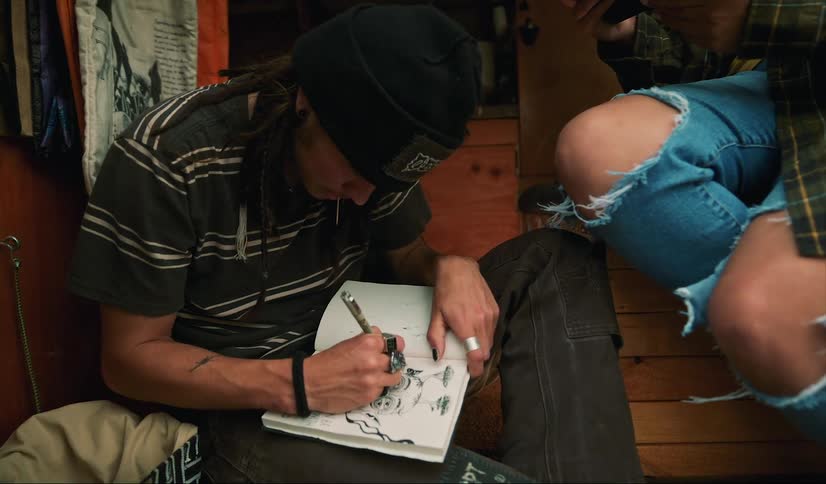 A man is sketching in a notebook