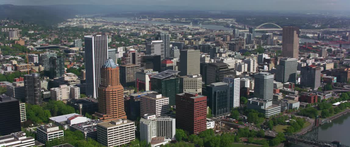 Aerail of city buildings and skyscapers next to river and bridges