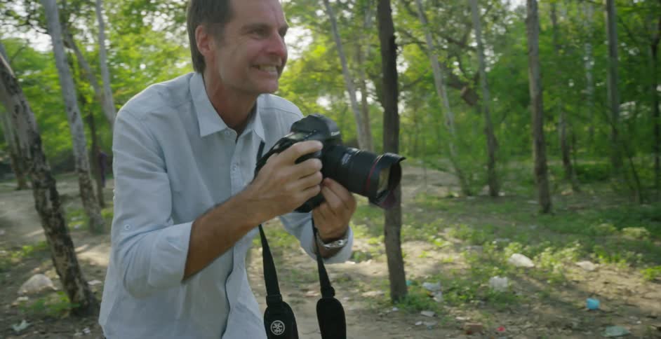 A man is photographing as he smiles