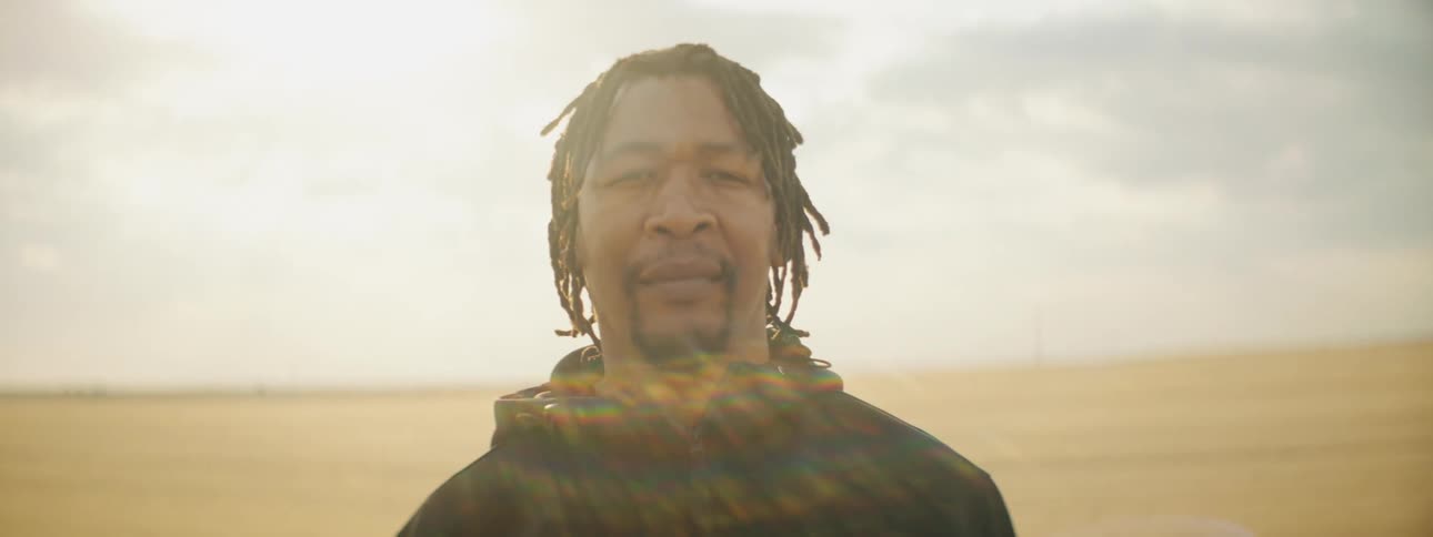 A man is standing outdoors in the desert