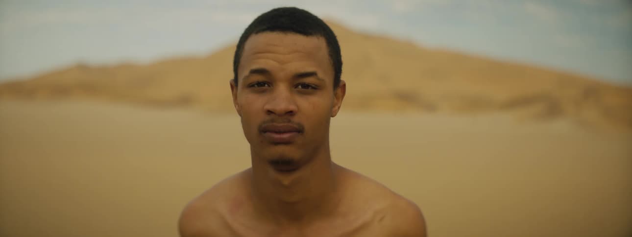 A man is standing in the desert alone