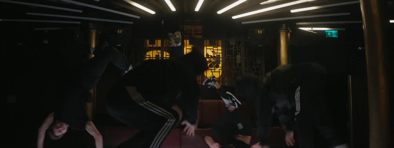 Men in a room breakdancing talking and laughing
