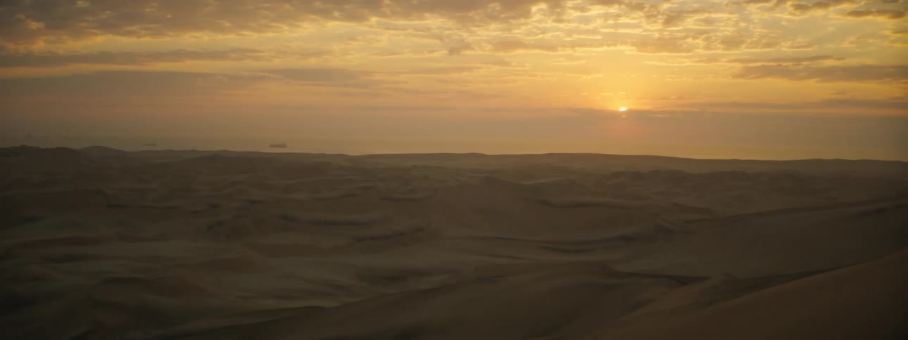 The sun rising over dunes