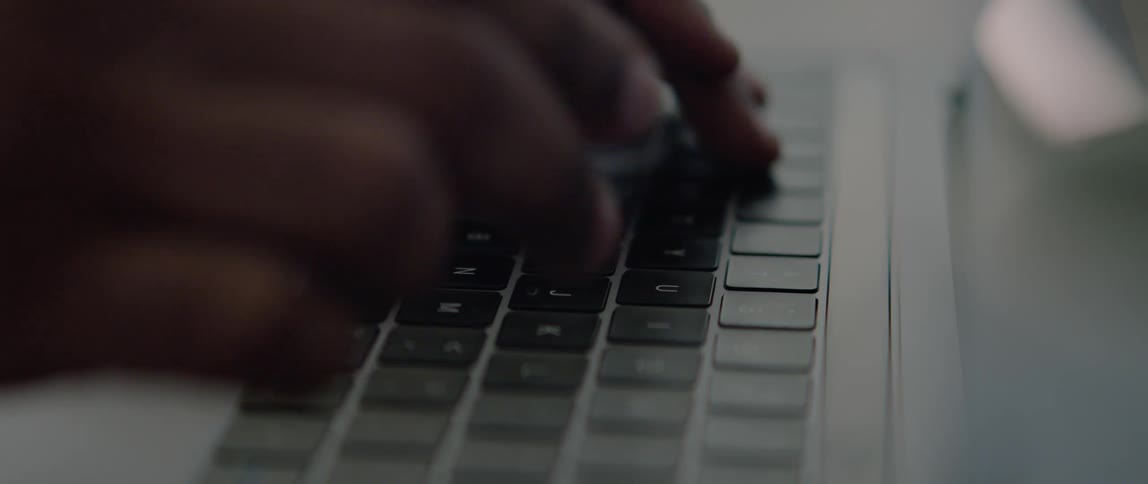 Person types on a laptop keyboard