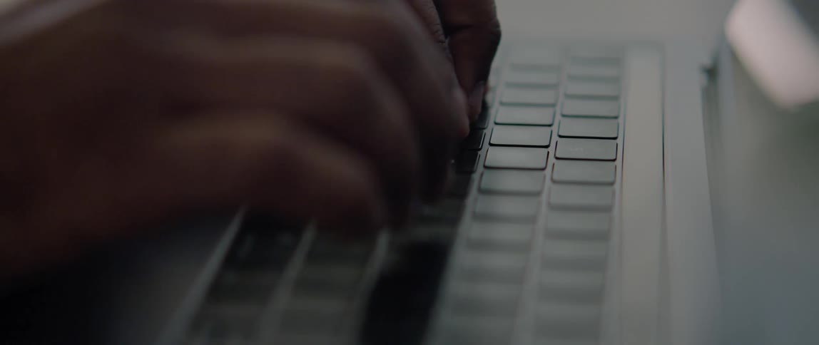 A man types on a laptop keyboard
