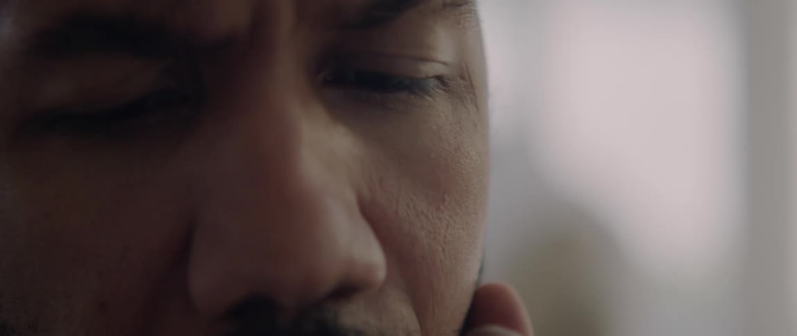 Man with mustache scratches his face while thinking