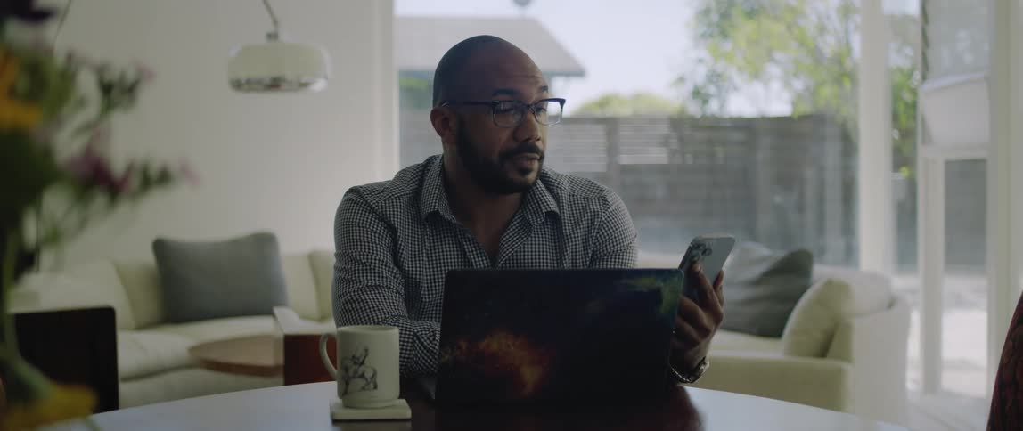A man sitting in a room using his laptop while on a video call