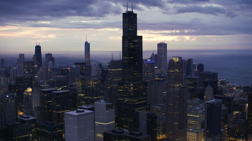 A city is lit up as the sun is going down