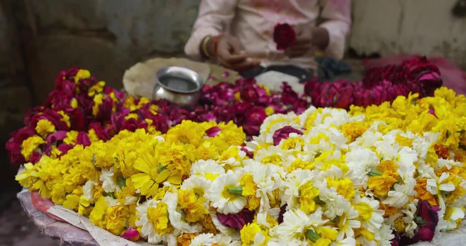 A man stringing flower garlands