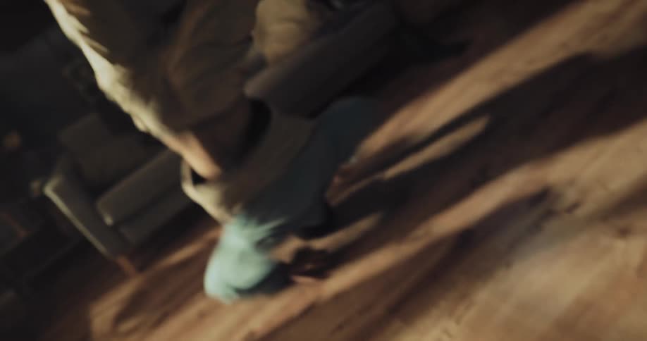 Young man energetically breakdancing on the living room at home