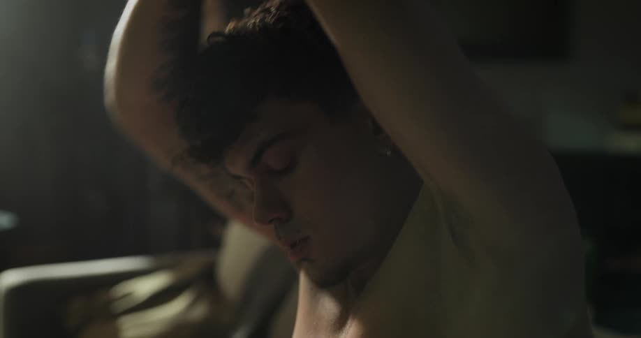 A man sitting on the floor in a living room stretching his arms shoulders and back