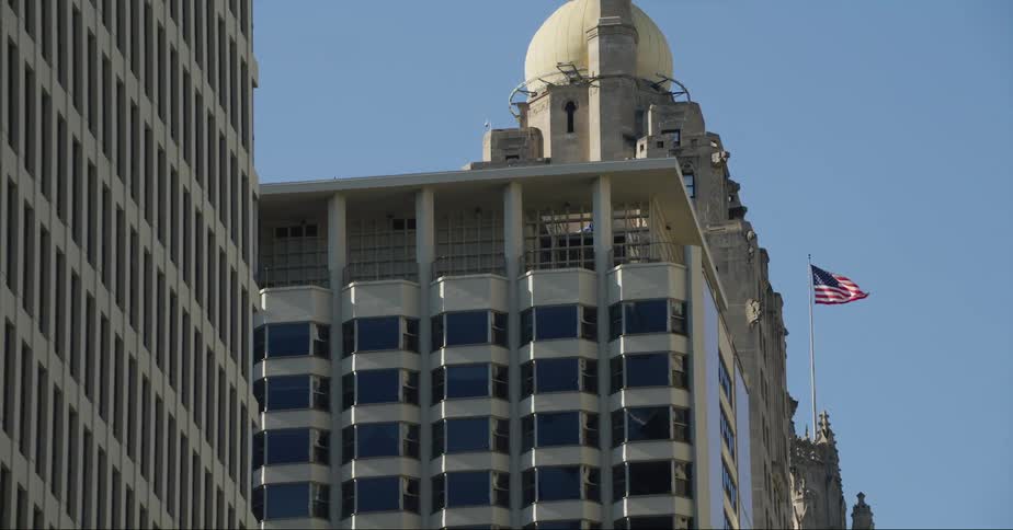 A domed building looms over the surrounding buildings in a city during the day