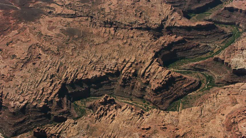 Vegetation borders riverbed winding through canyon