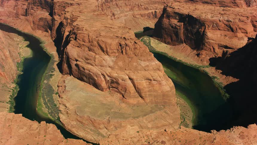 Green colored river flows through red rock canyon