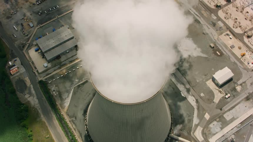 Heavy smoke rises from a smoke stack at a factory
