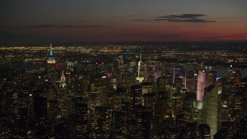 The empire state building with colorful lights in the new york city skyline