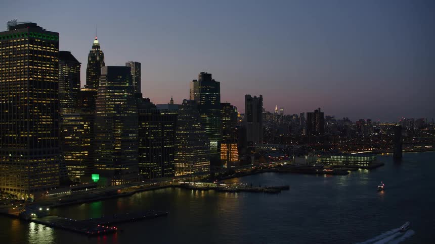 New york buildings and skyscrapers with ships docked and cars traveling at night