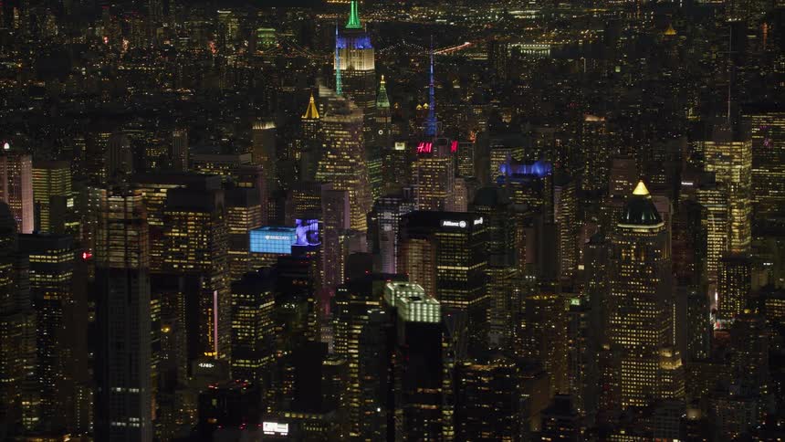 Lights on buildings and towers glow in the darkness as the big city is lit up at night