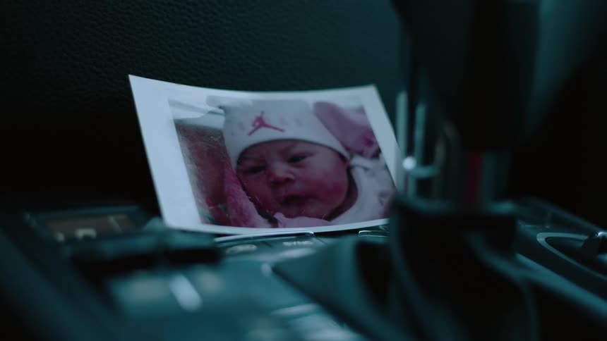 The photograph of a baby in a car behind the gear shift