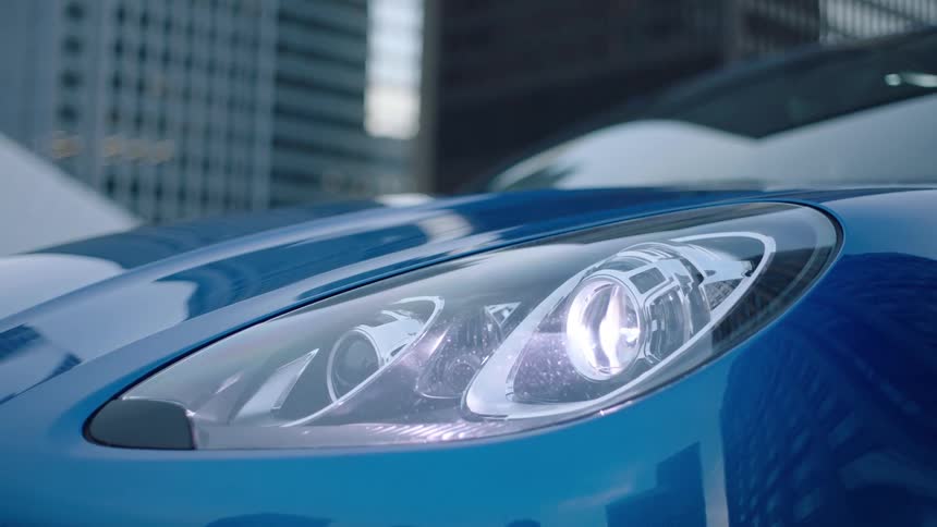 Moving headlights on a blue sports car moving up and down after turning on