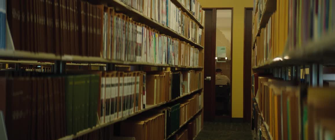 A man works at a desk in a library