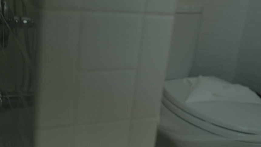 A little girl is in a bathroom pulling the toilet paper and playing with it