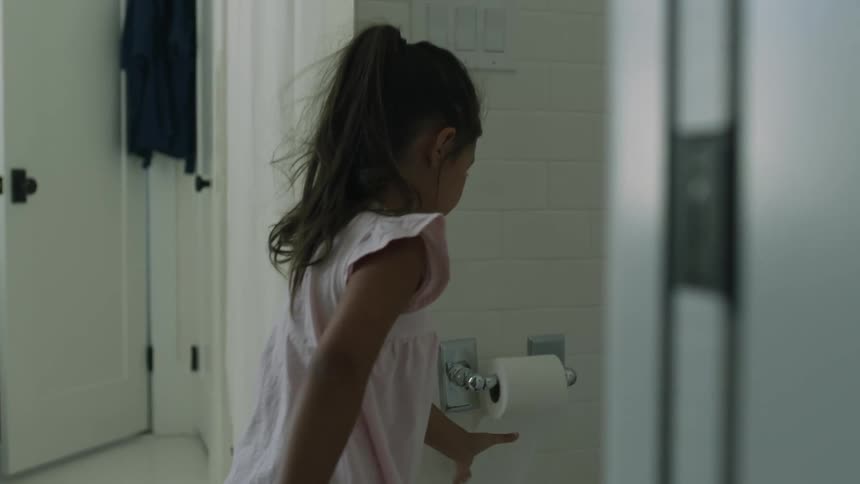 A child unravels the toilet paper