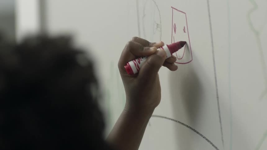 Kid draws on wall with a marker