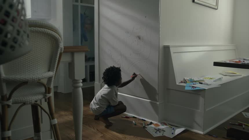 A child coloring on a wall