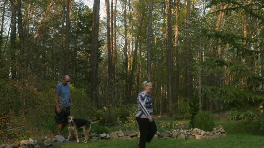 A view of two people and a dog walking outdoors