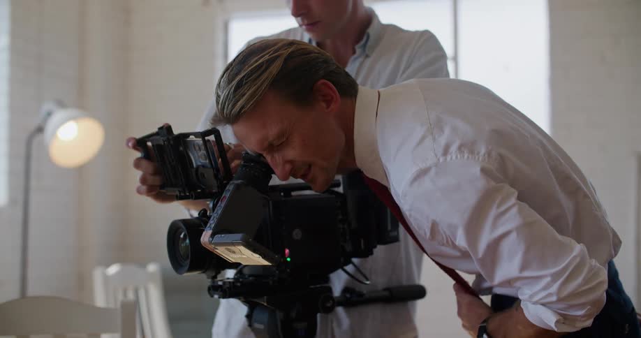 Two people using a video camera in a studio