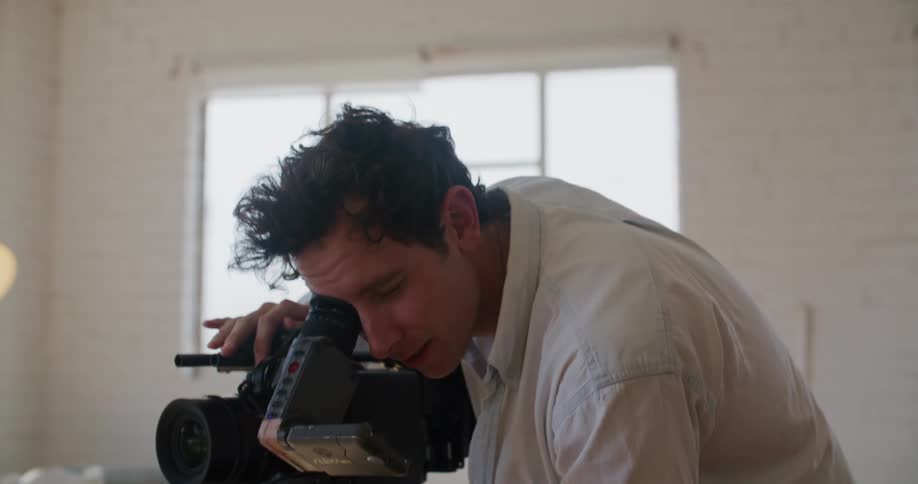 A man looking through a video camera