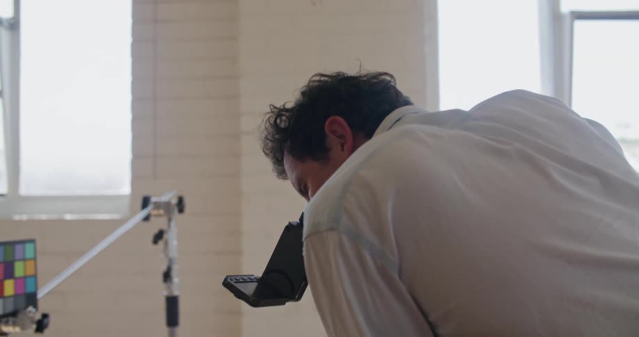 Two coworkers talking while filming in an office setting