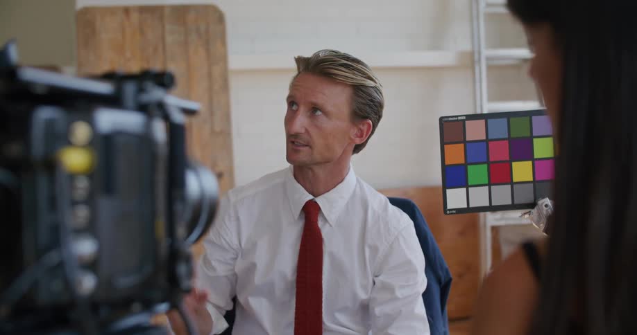 A man sitting in front of a camera talking