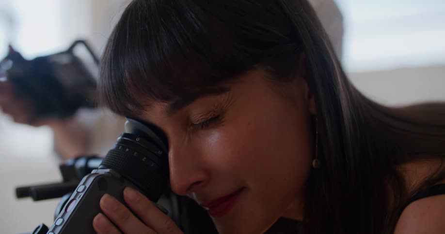 A woman leans over to look in the camera