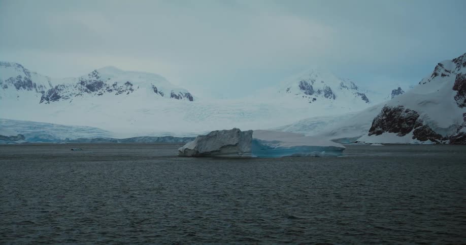An iceberg floating just off the coast in the arctic during the day