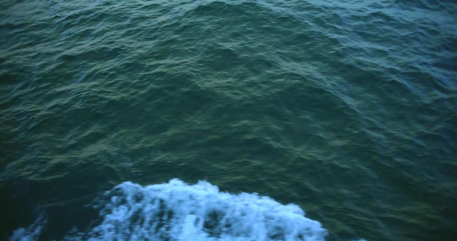 A white foam wake on the surface of the ocean waves
